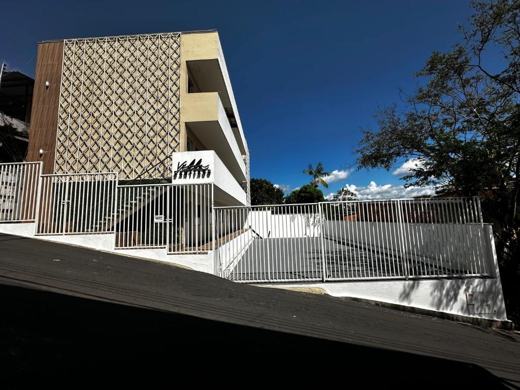 uma cerca branca em frente a um edifício em Villa Santiago em Manaus