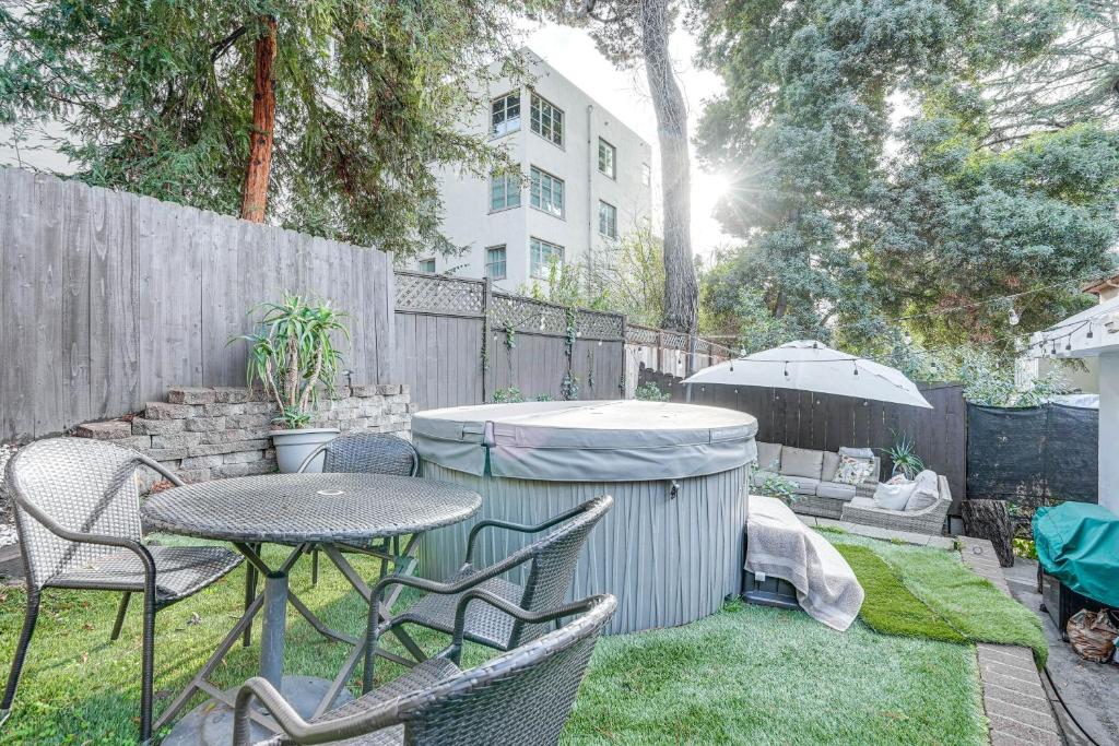 un patio con mesa, sillas y sombrilla en Oakland Apartment with Shared Hidden Backyard Oasis!, en Oakland