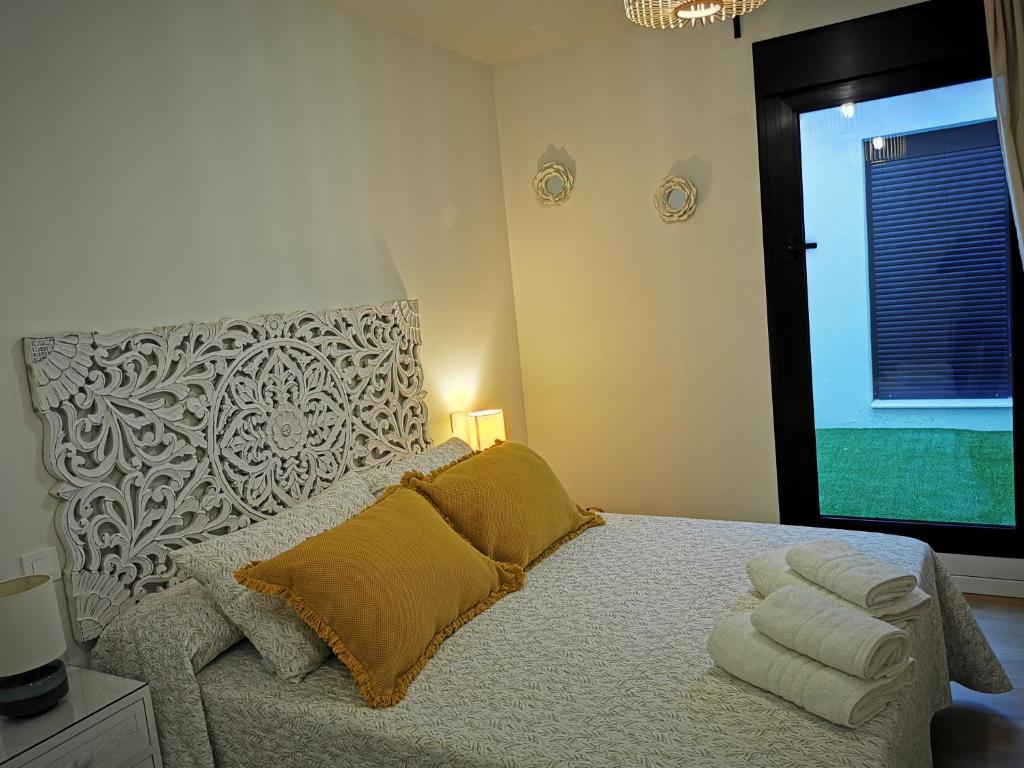 Un dormitorio con una cama con almohadas amarillas y una ventana en AGAETE PARADISE, en Puerto de las Nieves