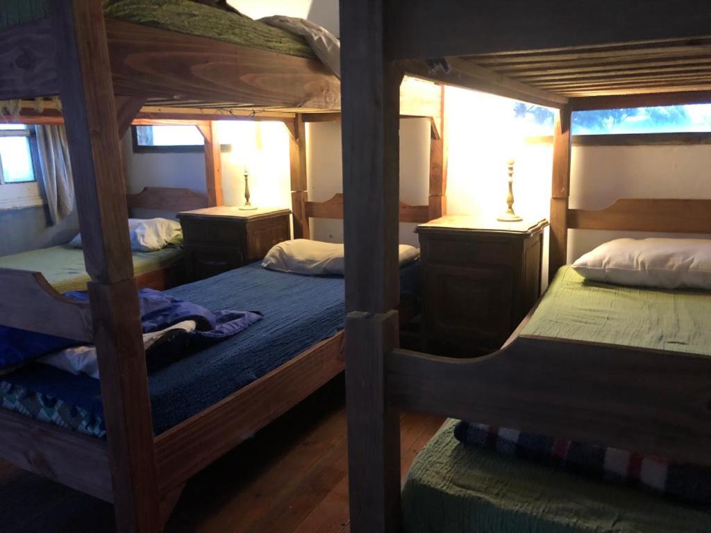 a bedroom with two bunk beds and two tables at La Peregrina - Posada in La Pedrera