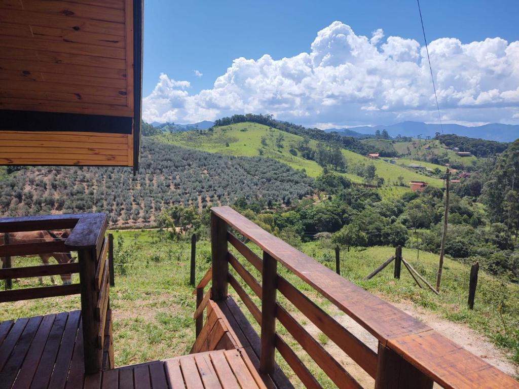 een houten terras met uitzicht op een berg bij Chalé Sítio São José in Santo Antônio do Pinhal
