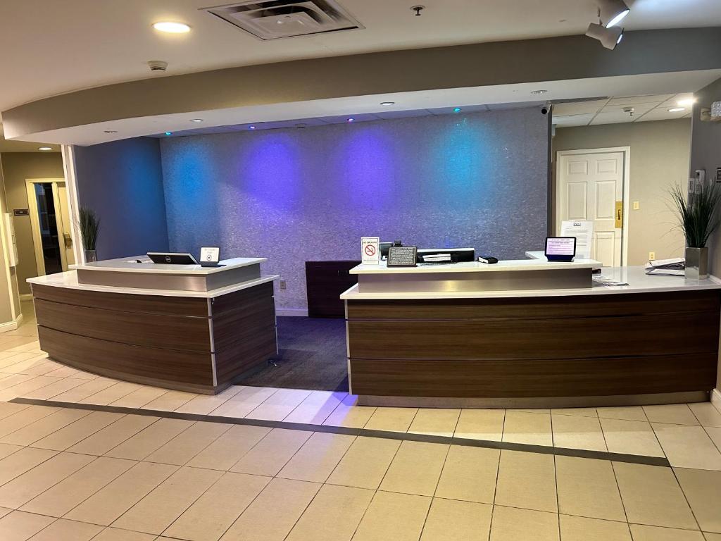 a lobby with two reception desks and a blue wall at ReVi Columbus North in Columbus