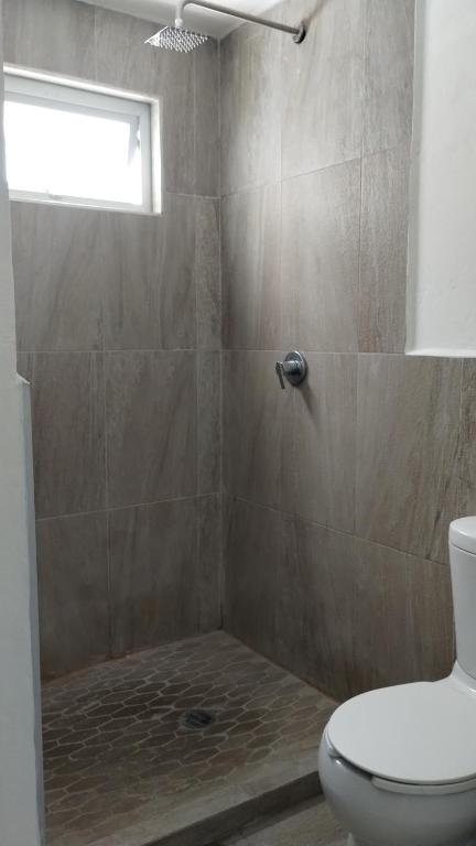 ein Bad mit Dusche, WC und Fenster in der Unterkunft Casa mami5 in Oaxaca de Juárez