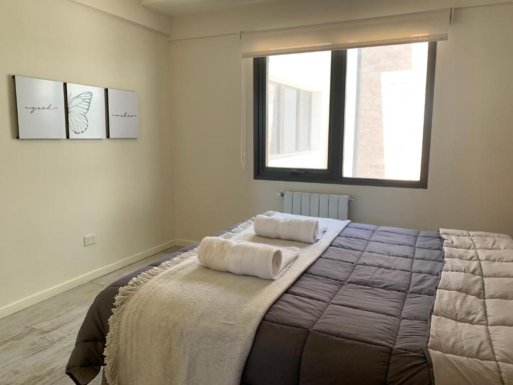 una camera da letto con un letto e due asciugamani di CyclosApart - Bariloche a San Carlos de Bariloche