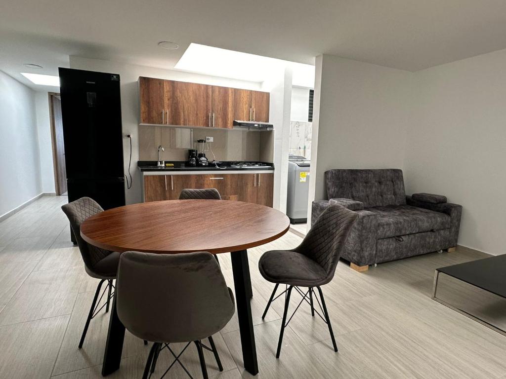 Apartamento Amoblado Pitalito في بيتاليتو: مطبخ مع طاولة وكراسي في غرفة