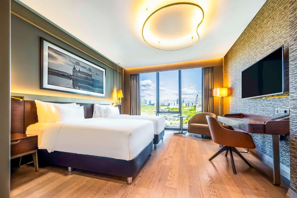 a hotel room with a bed and a desk and a computer at Radisson Collection Hotel, Vadistanbul in Istanbul