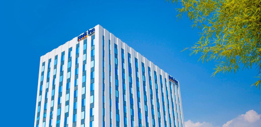 a tall building with a blue sky in the background at Park Inn by Radisson North Edsa in Manila