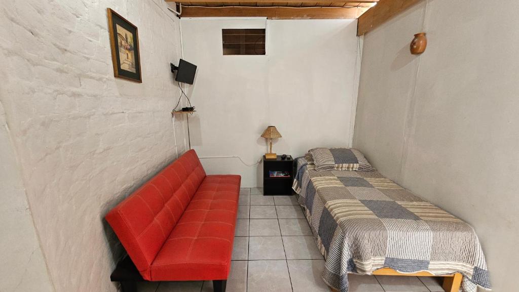 Zimmer mit einem Bett und einem roten Sofa in der Unterkunft La Casa Maruja in Lima