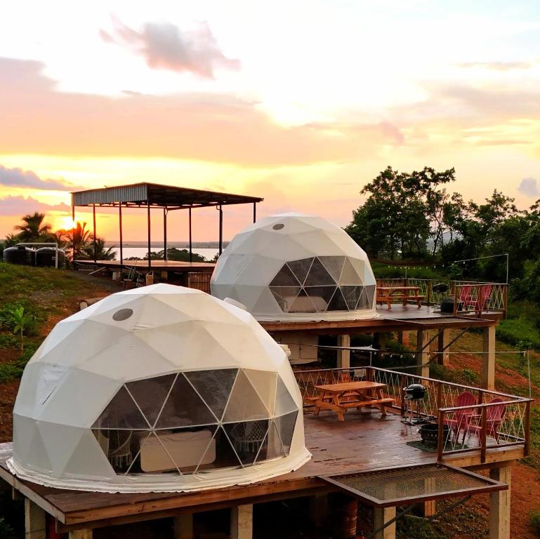 two domes on a wooden table with a sunset in the background at Domescape Glamping in El Cedro