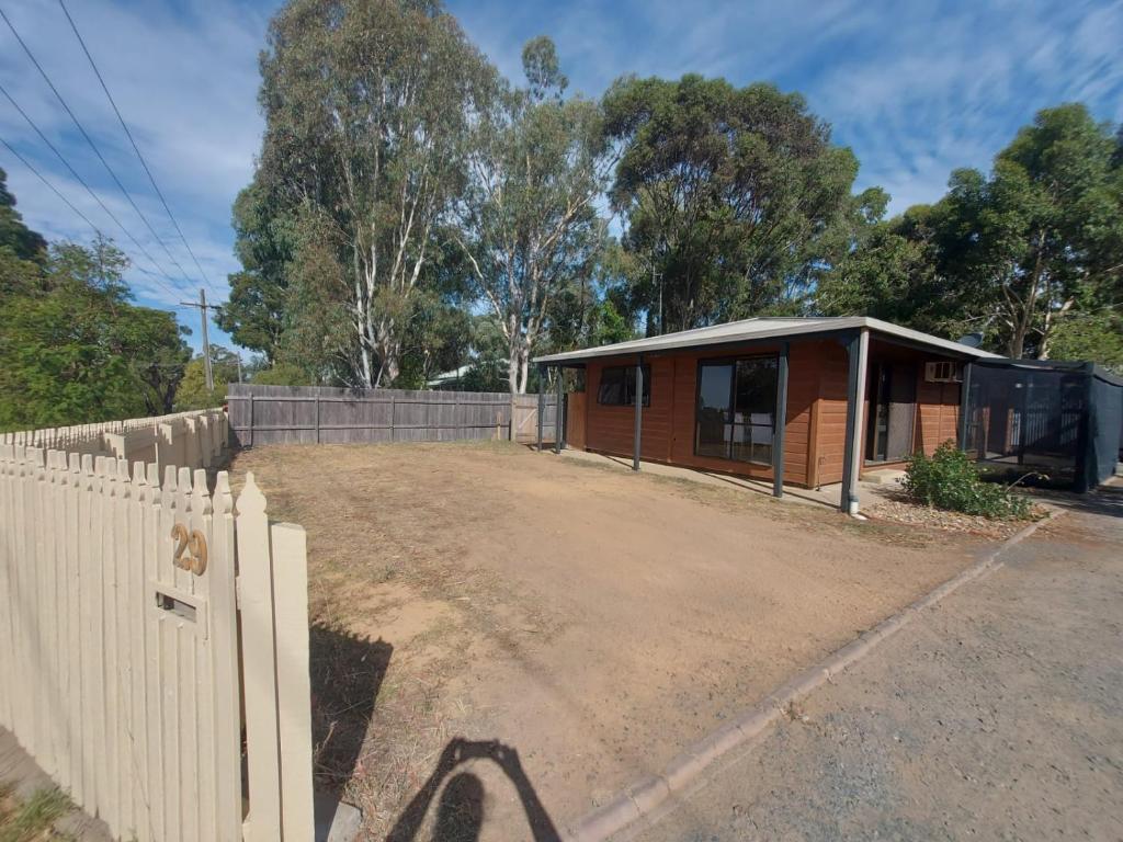 uma casa com uma cerca em frente em Bushland Cabin near Town, River and Restaurants em Echuca