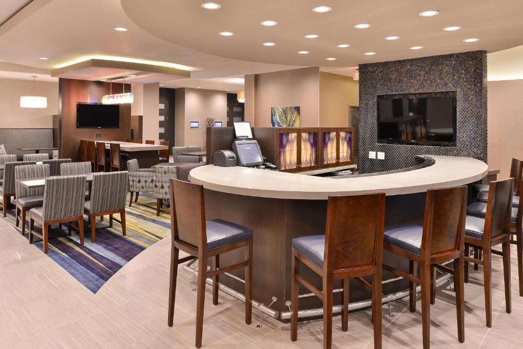 a bar in a waiting room with chairs at SpringHill Suites by Marriott Raleigh Cary in Cary