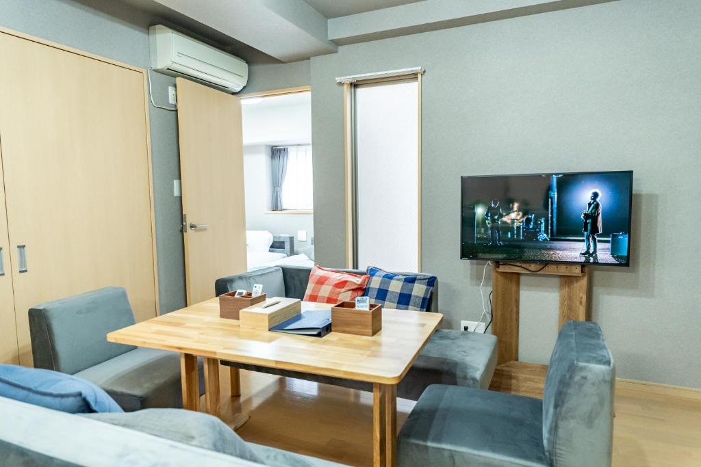 a living room with a table and a tv at Sun Route Hirano-cho, サンルート平之町 in Kagoshima