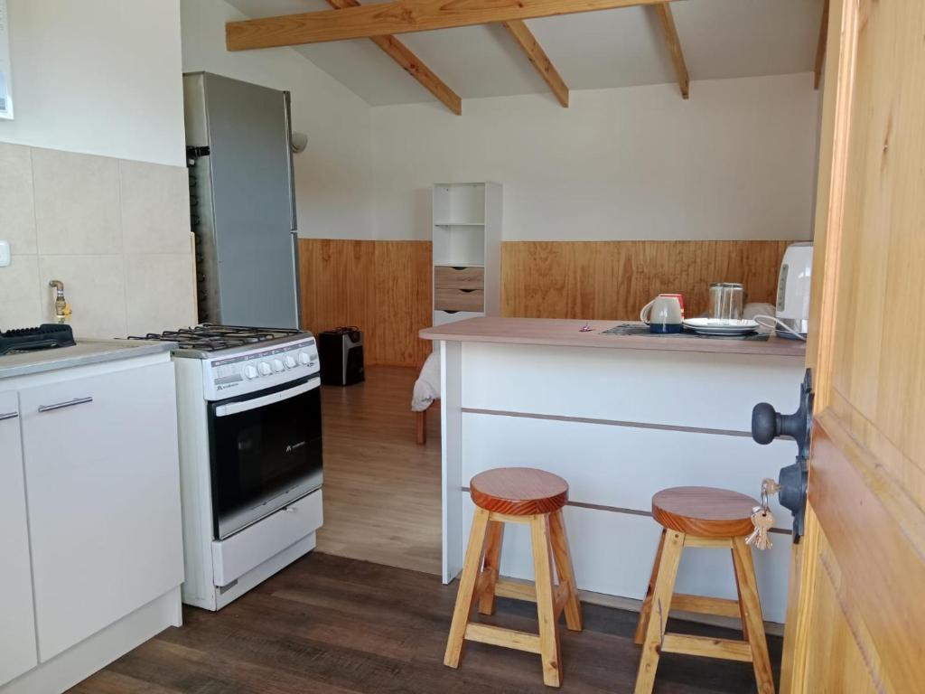 a kitchen with a counter and two stools at Ruta 7 in Coihaique