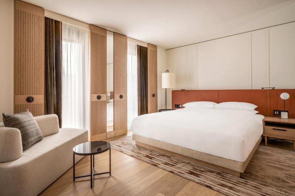 ミュンヘンにあるMunich Marriott Hotel City Westのベッドルーム(大きな白いベッド1台、ソファ付)