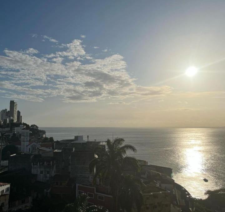 uma vista para o oceano e uma cidade com o sol em Apartamento no circuito do carnaval em Salvador