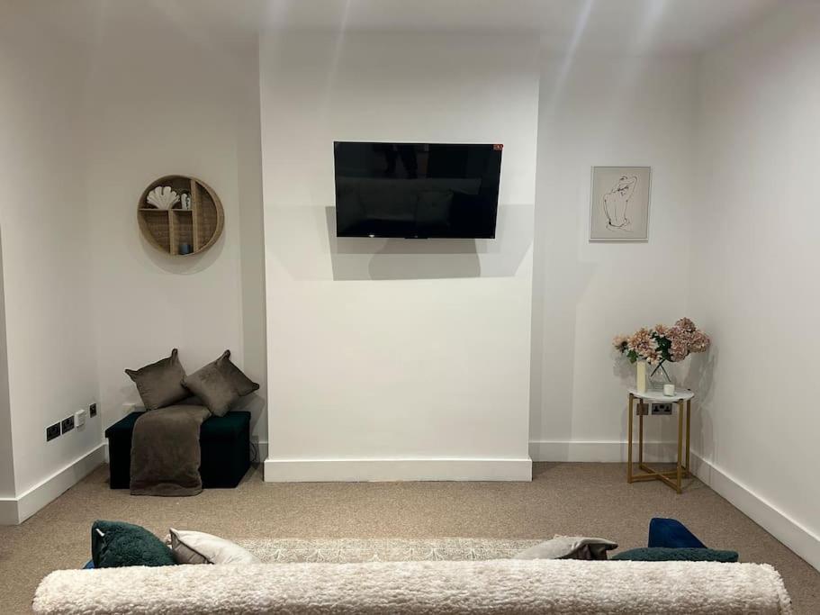 Il comprend un salon doté d'un canapé et d'une télévision à écran plat. dans l'établissement Tranquil Relaxing 2 Bed Apartment In Peterborough, à Peterborough