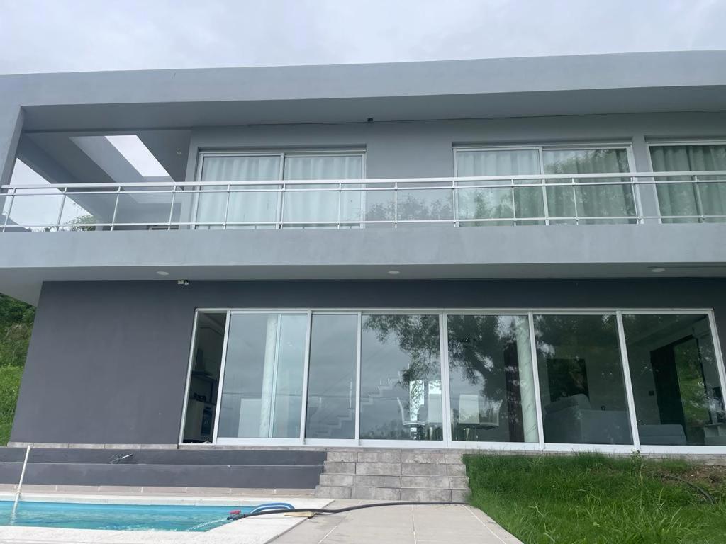 uma casa com uma varanda e uma piscina em Casa Soñada Solo uso familiar no fiestas no reuniones em Paraná