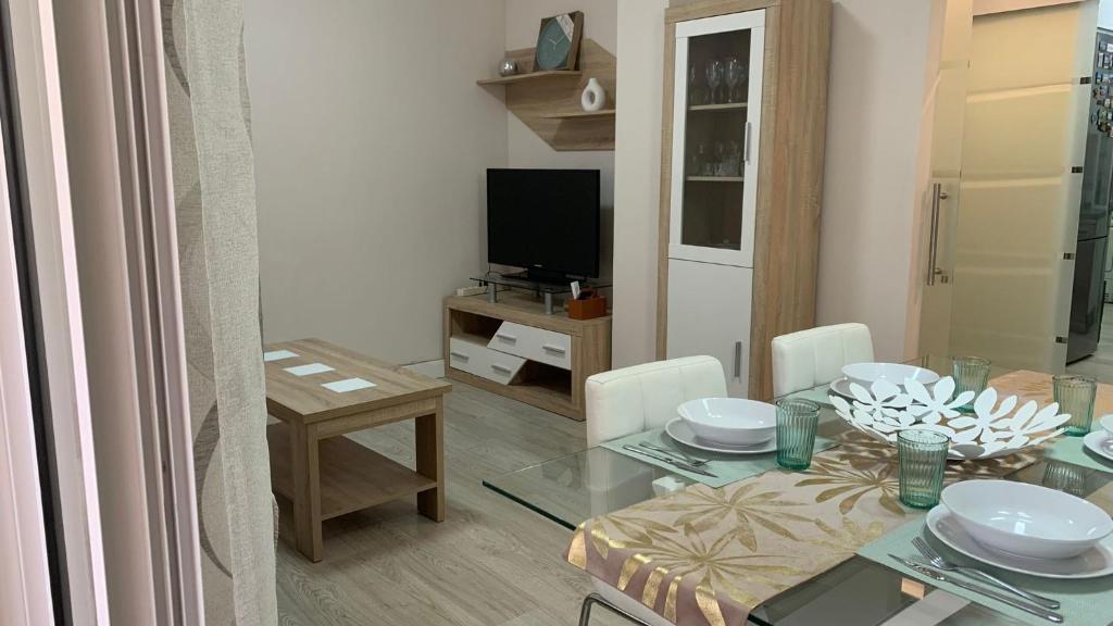a living room with a dining table and a television at Apartamento Parquesol in Antequera