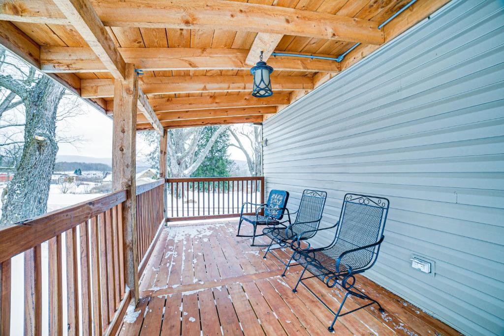 - deux chaises sur une terrasse couverte avec un toit en bois dans l'établissement Jones Mills Vacation Rental Near Skiing and Hiking!, 
