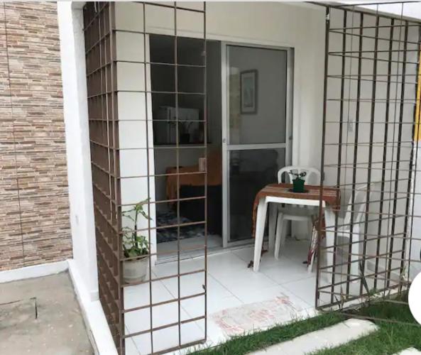 una pantalla en el porche de una casa con una mesa en CASA COMPACTA NO PRIVÊ COQUEIRAL COM GARAGEM, en Recife