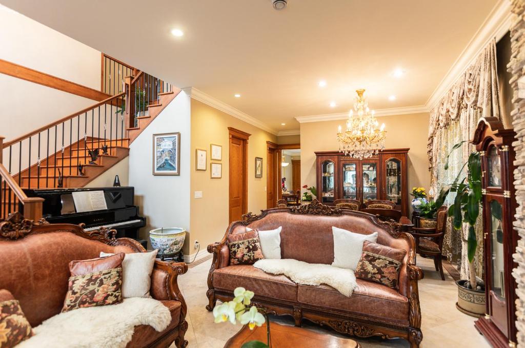 una sala de estar con 2 sofás y una escalera en An Yang House, en Burnaby
