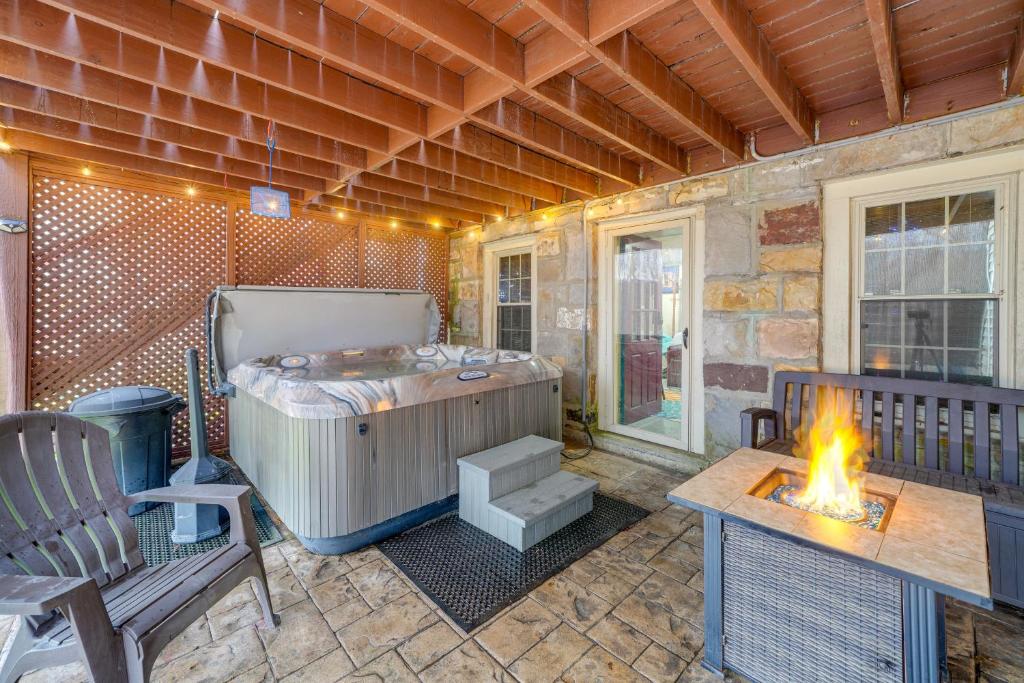 un patio con bañera de hidromasaje y chimenea en Beckley Studio with Private Hot Tub and Home Gym! en Beckley