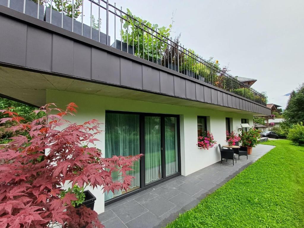 a house with a balcony with plants on it at Cozy apartment near the ski lifts in Jochberg