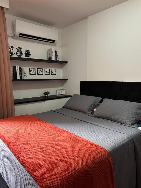 a bedroom with a bed with a red blanket on it at Flat em Brasília - Park Sul in Brasilia