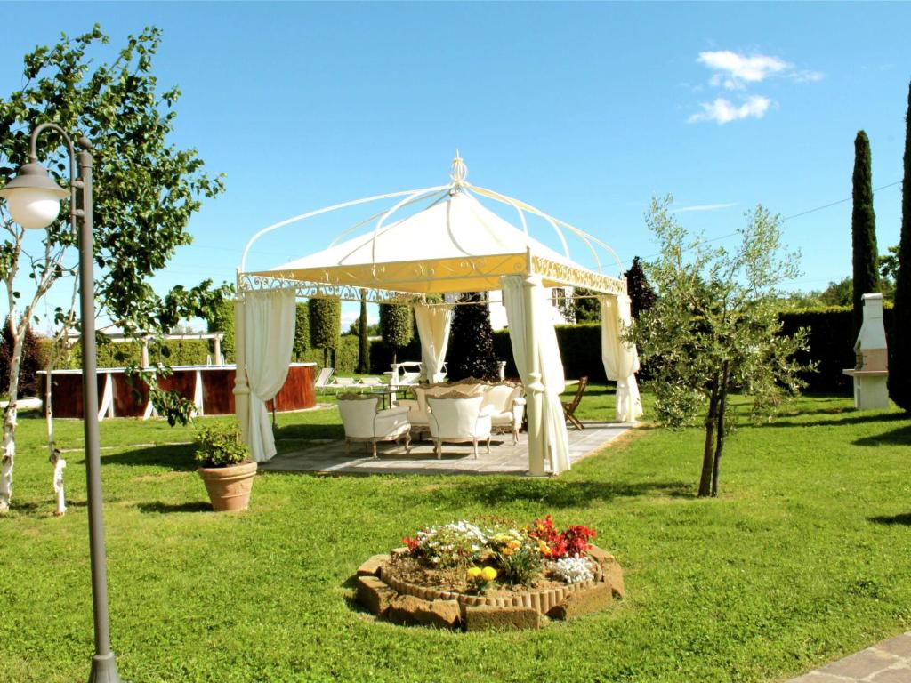 cenador en un jardín con mesa y sillas en Belvilla by OYO Montefiore, en San Piero in Campo
