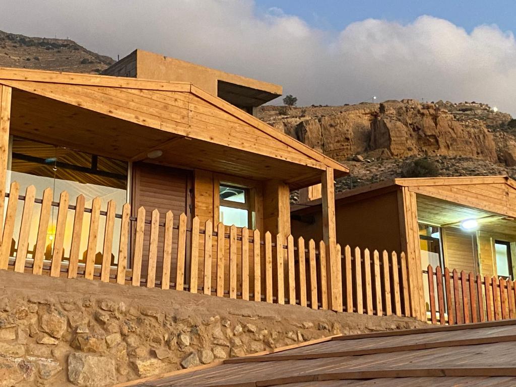 a house with a wooden fence in front of a mountain at Dana Trail Cottages in Dana