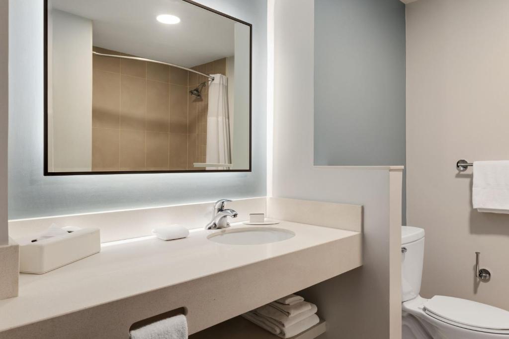 a white bathroom with a sink and a mirror at Courtyard by Marriott San Jose Airport Alajuela in Alajuela City