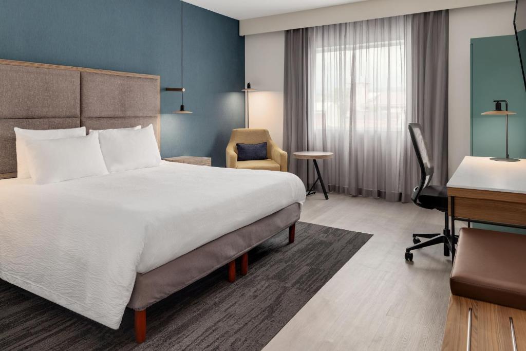 a hotel room with a large bed and a desk at Courtyard by Marriott San Jose Airport Alajuela in Alajuela City
