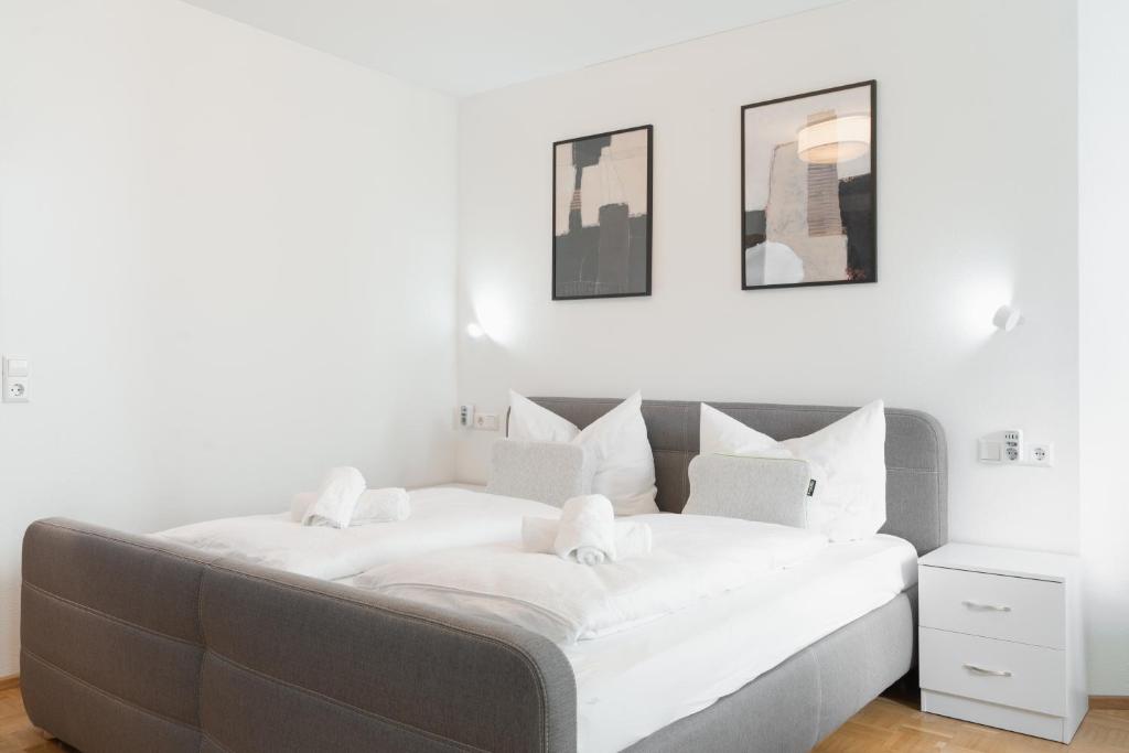 a bedroom with a large bed with white sheets at Untersee-Suite IStayUnixI Seenähe-Terrasse-Workspace-Netflix-Parkplatz in Radolfzell am Bodensee