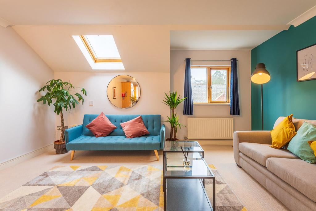 a living room with a blue couch and a mirror at 2 bedroom Apartment - Free secure parking - City Centre - Sleeps up to 5-6 in Exeter