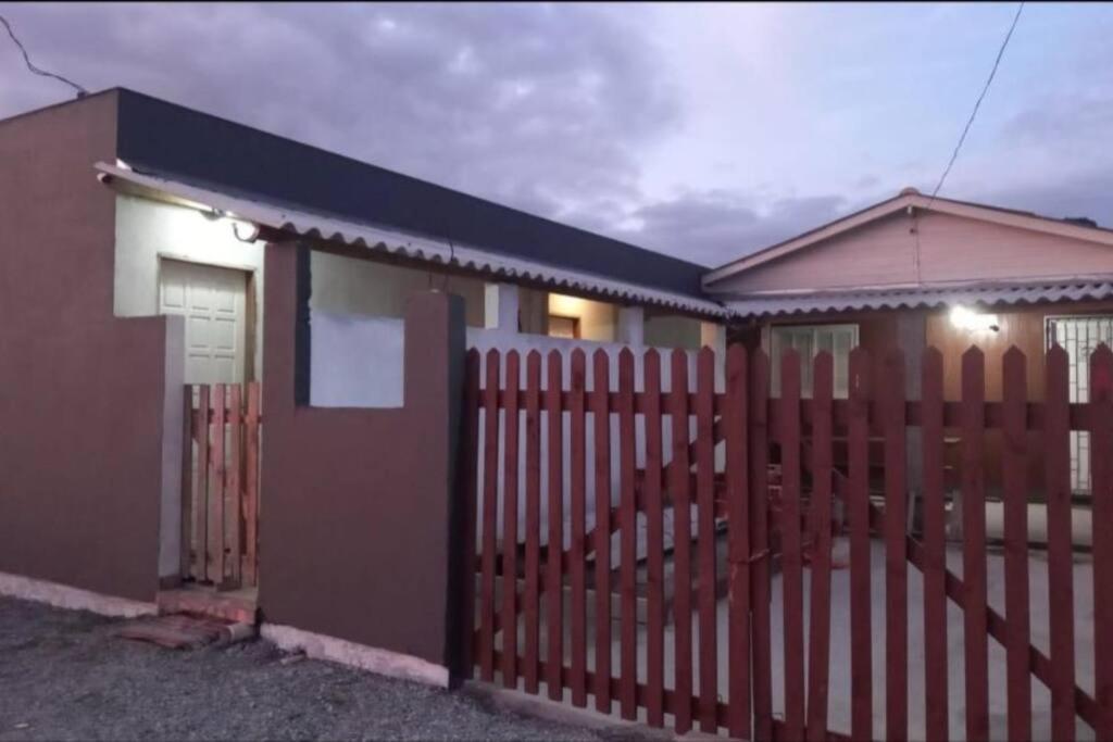 une maison avec une clôture en bois et un portail dans l'établissement Casa Temporada Praia do Sonho, à Palhoça