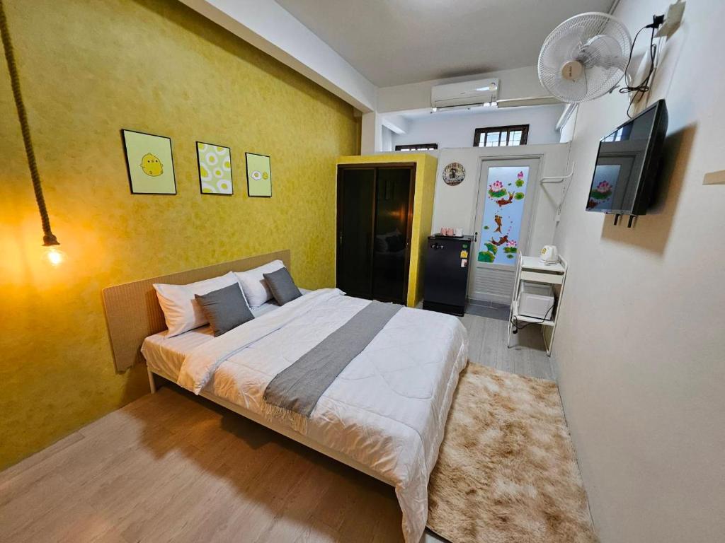 a bedroom with a bed and a tv in it at Hommie by De-A-Ga in Ban Bang Talat