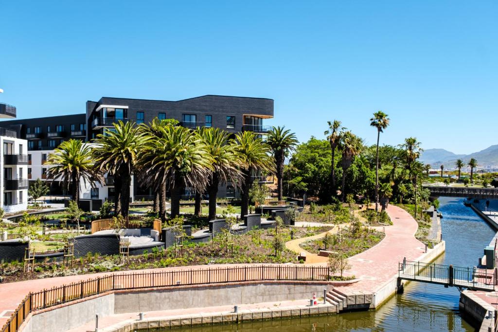 vistas a un río con palmeras y a un edificio en Belina - Nine Palms Premier, en Ciudad del Cabo