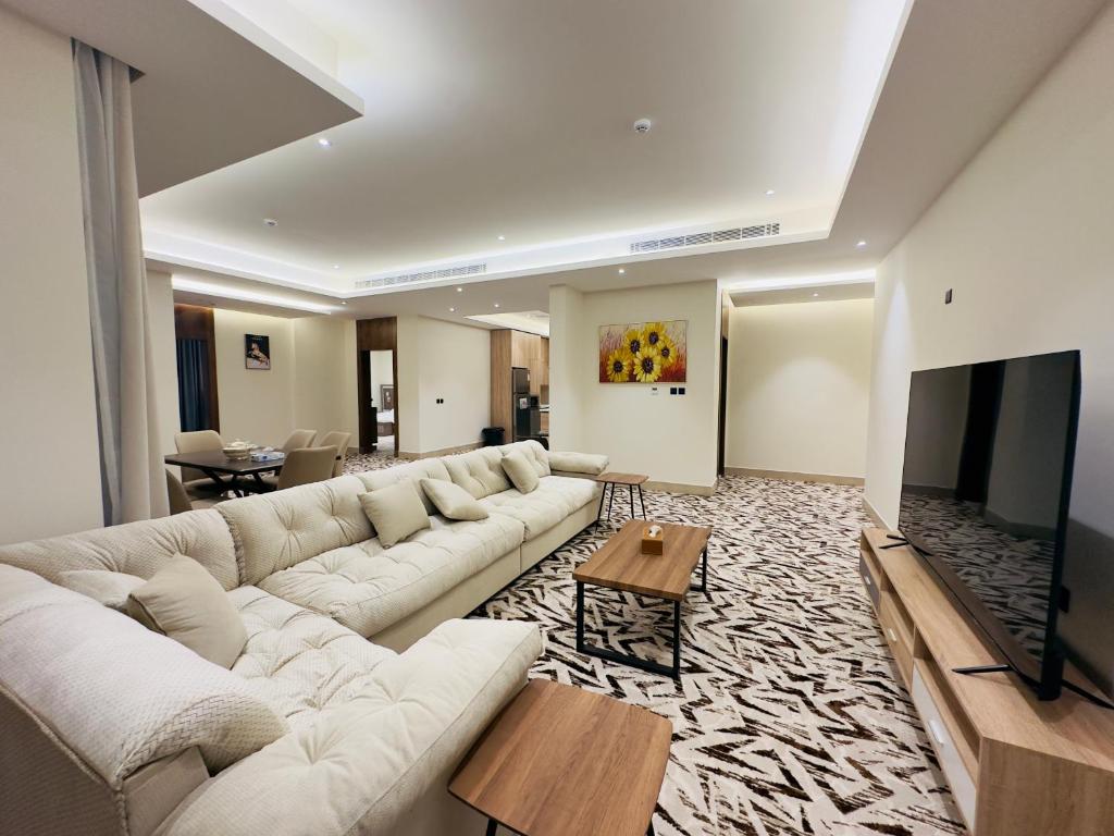 un soggiorno con un grande divano e una TV di REMAZ ROSE BOULEVARD a Riyad