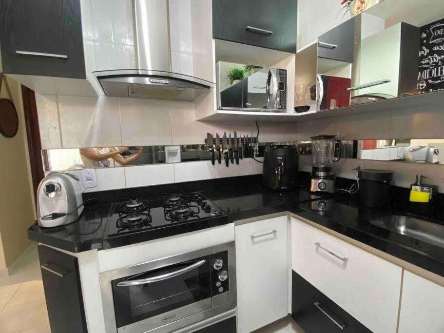 a kitchen with a stove and a microwave at Duplex em condomínio fechado in Campina Grande