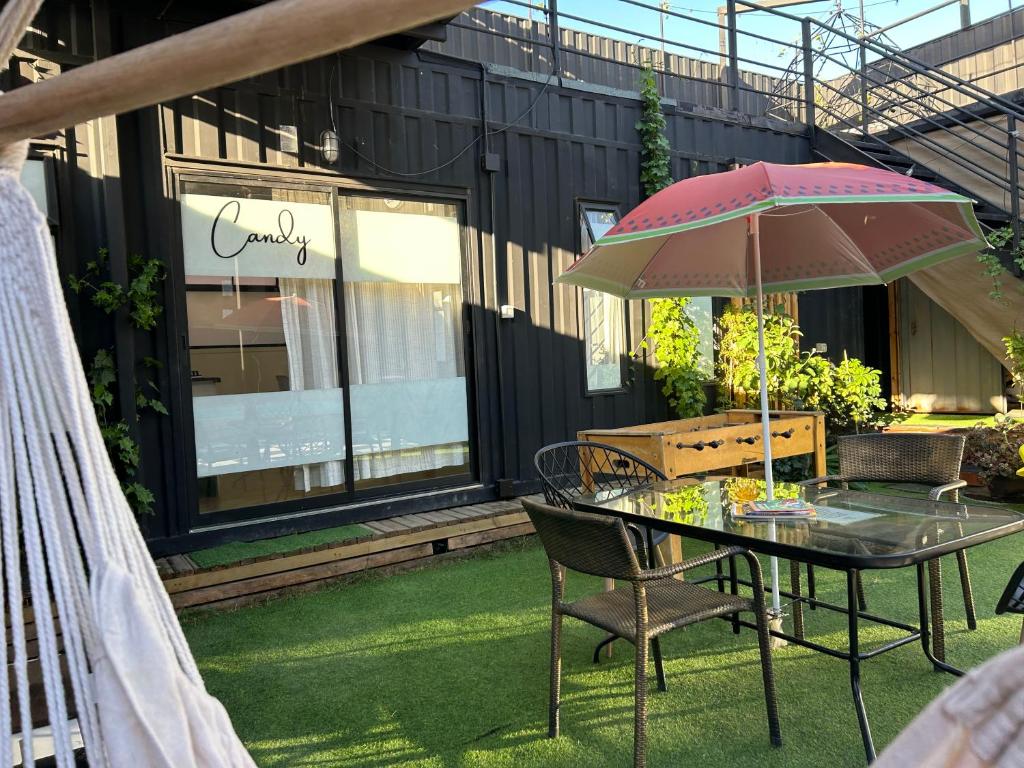 a table and chairs with an umbrella in a yard at Beehouse Casa Miel Villa Alemana in Villa Alemana