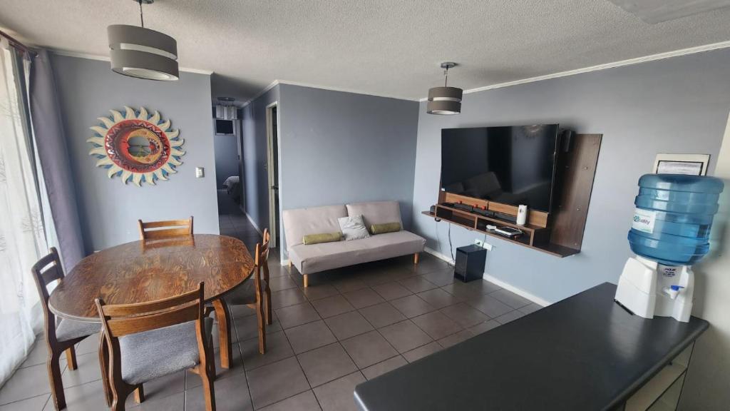 a living room with a dining table and a tv at Departamento 3d y 2b condominio mistral oriente 2 in La Serena