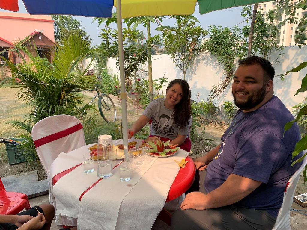 a man and woman sitting at a table with a plate of food at Sarkar Villa Homestay in Kolkata