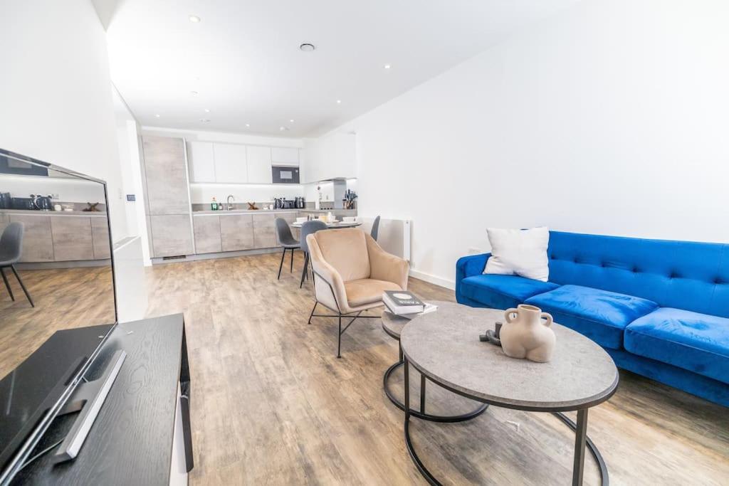 a living room with a blue couch and a table at City Escape - Unwind in Style in Barking