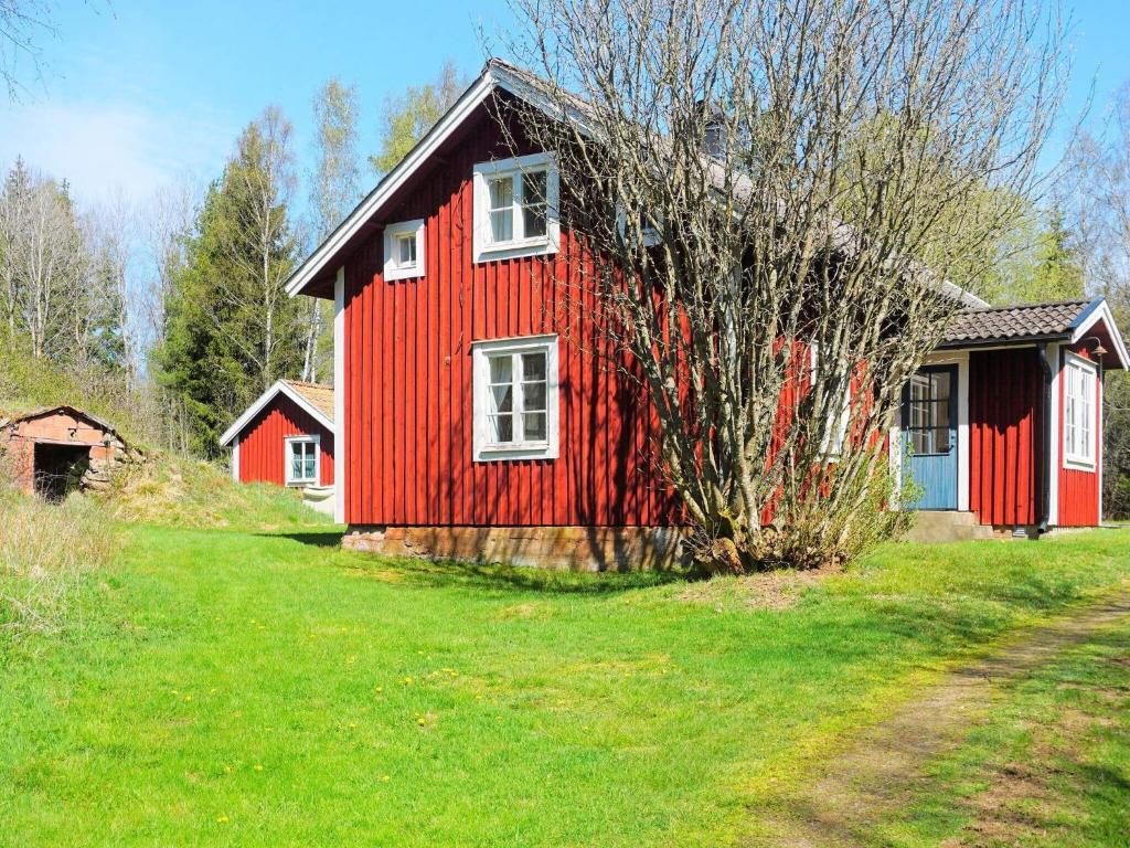 Tingsryd的住宿－Holiday home TINGSRYD VI，绿地中的红色房子,有树