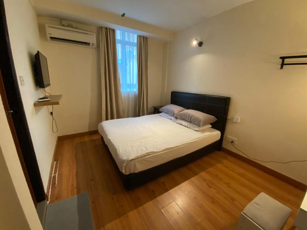 a small bedroom with a bed and a television at GN Homestay Miri in Miri