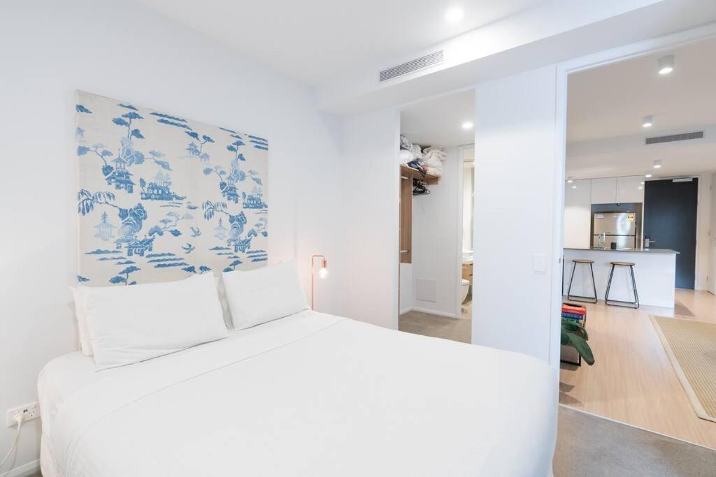 a bedroom with a bed with a blue and white patterned headboard at West End Executive Suite, on the Brisbane River. in Brisbane