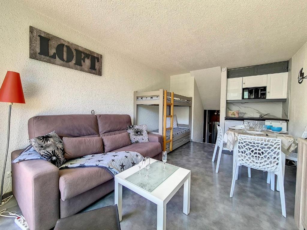 un salon avec un canapé et une table dans l'établissement Studio rénové - Pied des pistes, balcon sud - FR-1-344-1193, aux Menuires