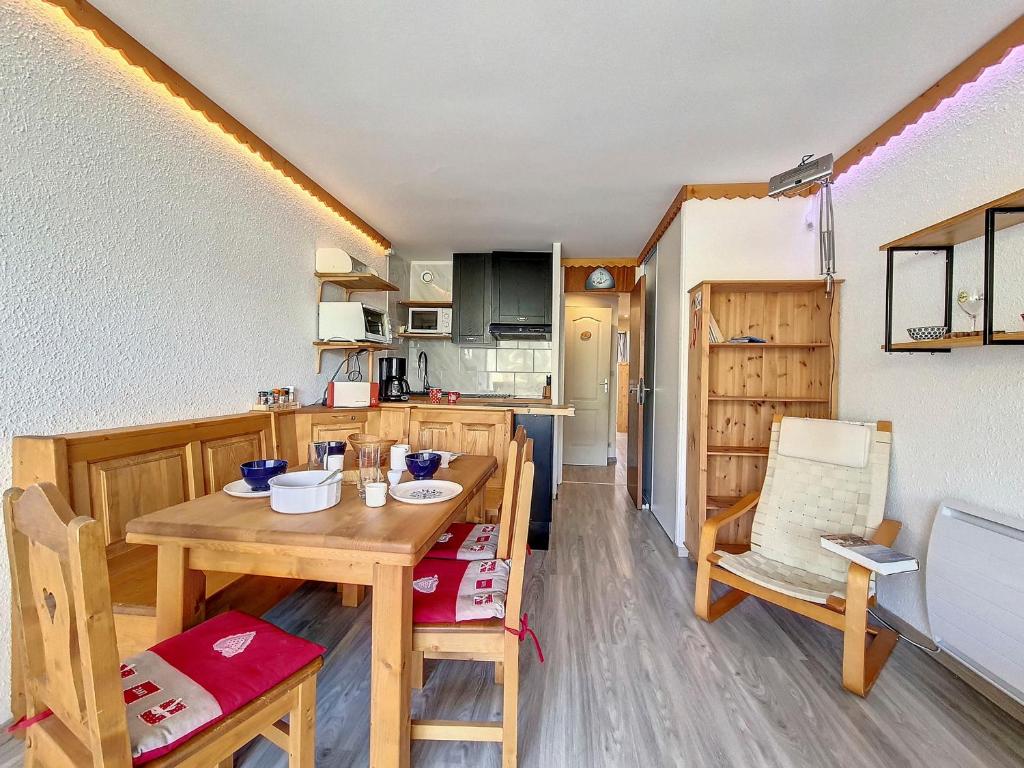 une cuisine et une salle à manger avec une table et des chaises en bois dans l'établissement Appartement lumineux 5 pers · Pied des pistes · Balcon sud · 2 flocons Argent - FR-1-344-1200, aux Menuires