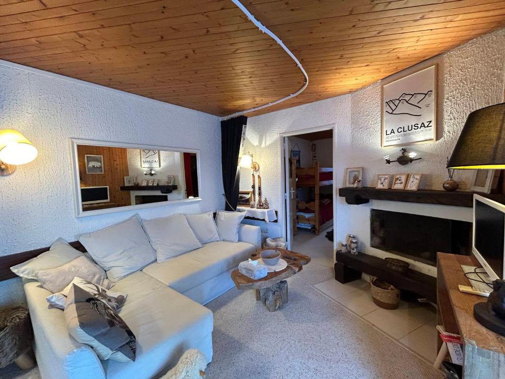 a living room with a white couch and a television at Appartement La Clusaz, 3 pièces, 6 personnes - FR-1-437-110 in La Clusaz