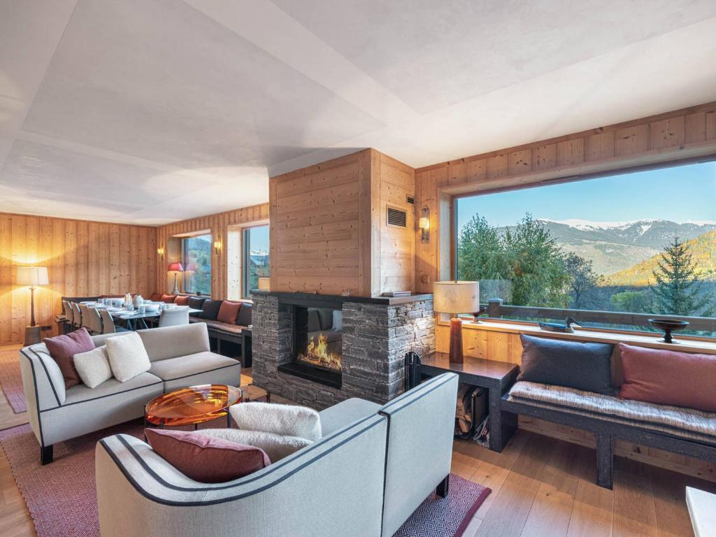 ein Wohnzimmer voller Möbel und einem Kamin in der Unterkunft Chalet spacieux pour 14 personnes avec sauna et parking à Méribel - FR-1-566-65 in Les Allues